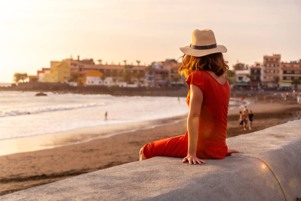 Tourist woman with hat at sunset on vacation on the beach of Valle Gran Rey village on La Gomera, Canary Islands - Photo, image