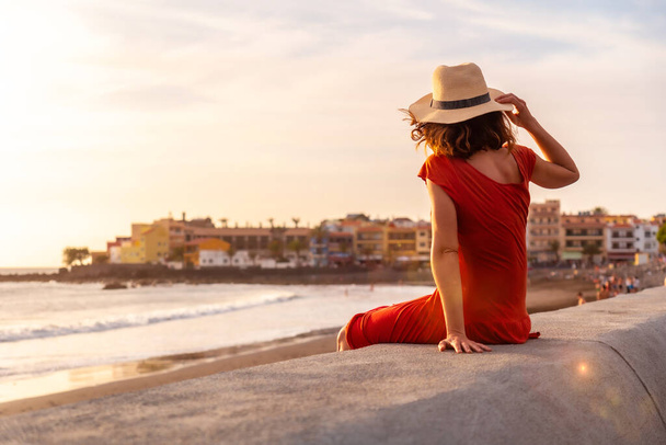 Tourist woman with hat at sunset on vacation on the beach of Valle Gran Rey village on La Gomera, Canary Islands - Foto, afbeelding