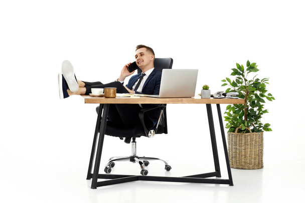 Successful happy businessman working with laptop and having phone conversation with client - Photo, Image