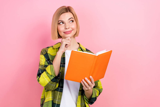Portrait of pretty smart girl hand touch chin hold book look empty space contemplate isolated on pink color background. - Foto, Imagem