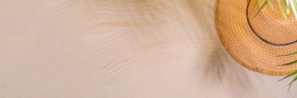 Summer sunny sand flat lay with straw hat, flip flops and seashells, on sea sand background copy space - Фото, зображення