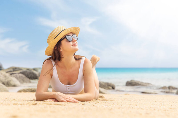 Kobieta leżąca na plaży, ciesząca się latem i relaksująca - Zdjęcie, obraz