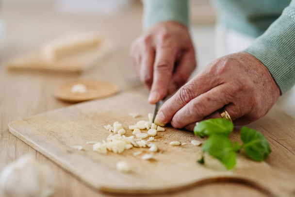 Close up of senior man cutting a garlic. - Foto, immagini