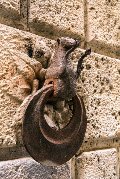 Rusty and weathered metal horse hitching ring on a wall of an old building in Siena, Tuscany, Italy. - Foto, Imagem