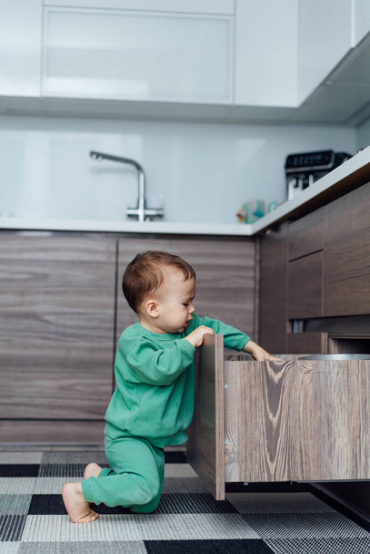 Little boy playing with shelves. Indoor playful kid sitting on the floor. - 写真・画像