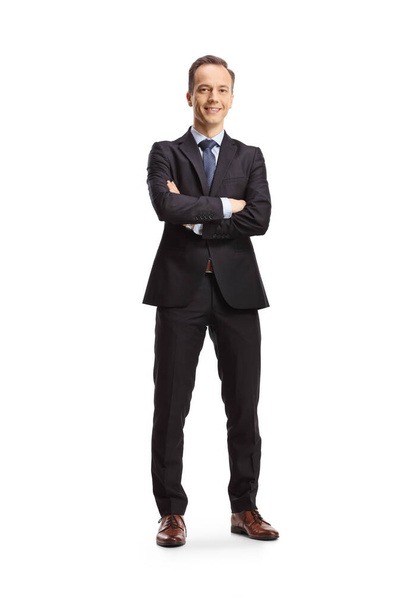 Full length portrait of a businessman standing with folded arms and smiling isolated on white background - Foto, Imagem