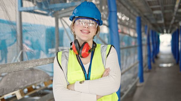 Young blonde woman architect smiling confident standing with arms crossed gesture at street - Photo, image