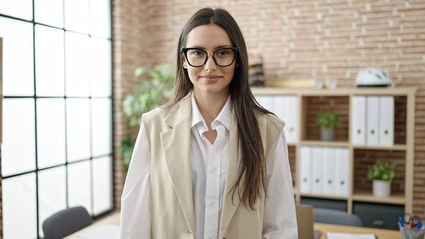 Jovem bela mulher hispânica empresária sorrindo confiante no escritório - Foto, Imagem