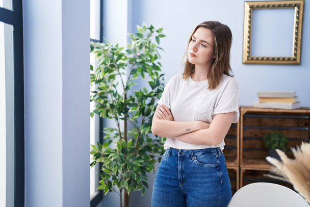 Young woman standing with arms crossed gesture at home - Foto, Imagem
