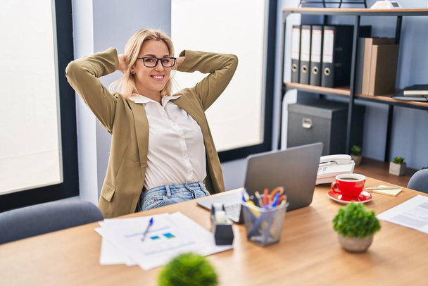 Fiatal szőke nő üzleti dolgozó pihentető kezét a fejét az irodában - Fotó, kép