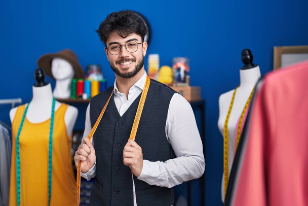Young hispanic man tailor smiling confident standing at sewing studio - Фото, изображение