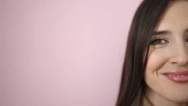 Όμορφη ισπανόφωνη γυναίκα χαμογελά αυτοπεποίθηση στέκεται πάνω από απομονωμένο ροζ φόντο - Φωτογραφία, εικόνα