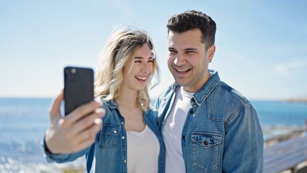 mężczyzna i kobieta para stojąc razem zrobić selfie przez smartfon na wybrzeżu - Zdjęcie, obraz