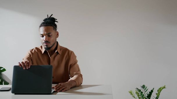Ciddi bir adam evde dizüstü bilgisayar açıyor. Genç adam çatı katında çalışmaya başladı. Afrika kökenli Amerikalı serbest yazar tek başına masa başında klavye çalar. Akıllı öğrenci içeride bilgisayar kullanıyor.  - Fotoğraf, Görsel