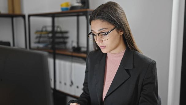 Young beautiful hispanic woman business worker using laptop working at office - Zdjęcie, obraz
