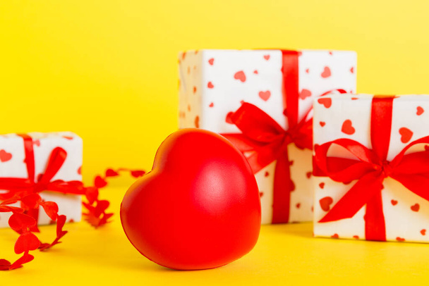 gift box with red bow and red heart on colored background. Perspective view. Flat lay. - Foto, Imagen