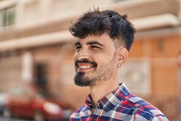 Young hispanic man smiling confident looking to the side at street - Fotó, kép