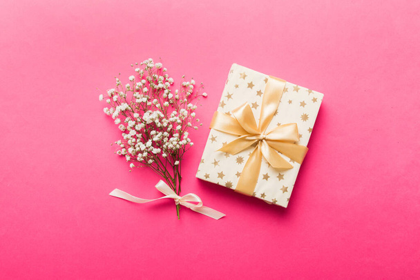 Cadeau ou boîte cadeau et fleur gypsophila sur table lumineuse vue de dessus. Carte de vœux. Style de pose plat avec espace de copie. - Photo, image