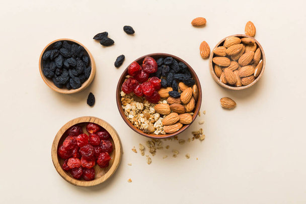 Cooking a wholesome breakfast. Granola with Various dried fruits and nuts in a bowl. The concept of a healthy dessert. Flat lay, top view with copy space. - Zdjęcie, obraz