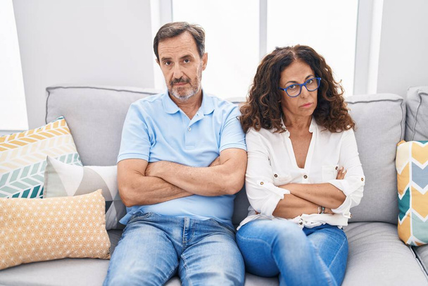 Man and woman couple sitting on sofa with serious expression at home - Photo, image