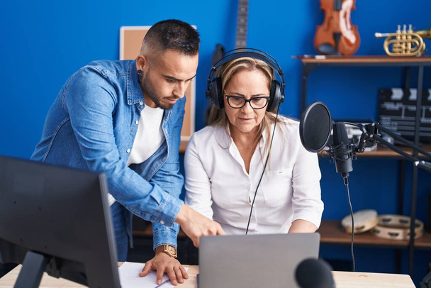 Мужчины и женщины-музыканты слушают музыку в музыкальной студии - Фото, изображение