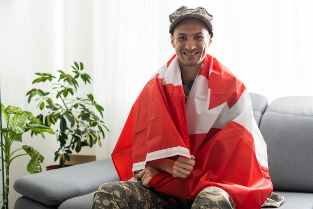 visão parcial do homem de uniforme militar que ostenta bandeira nacional do Canadá - Foto, Imagem