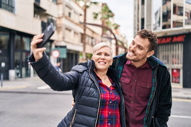 Matka a syn se usmívá sebevědomě dělat selfie u smartphonu na ulici - Fotografie, Obrázek