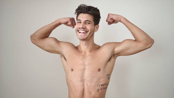 Nuori latino mies hymyilee luottavainen tekee vahvan eleen kädet yli eristetty valkoinen tausta - Valokuva, kuva