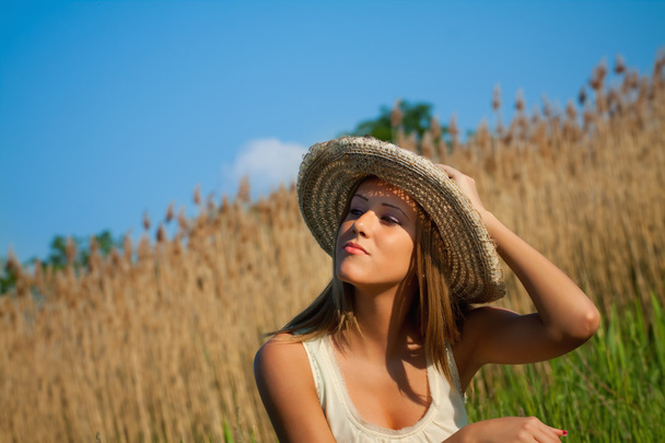 Beautiful brunette lady in wheat field at sunset - Foto, imagen