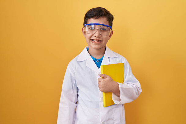 Pequeño niño hispano usando gafas científicas que se ven positivas y felices de pie y sonriendo con una sonrisa confiada mostrando los dientes  - Foto, imagen