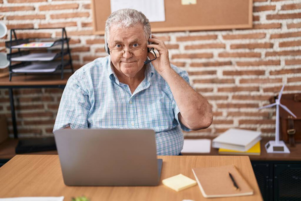 Keski-ikäinen harmaatukkainen mies liiketalouden työntekijä, jolle on tehty videopuhelu toimistossa - Valokuva, kuva