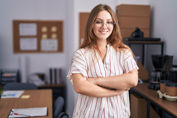 Young blonde woman business worker standing with arms crossed gesture at office - Fotografie, Obrázek