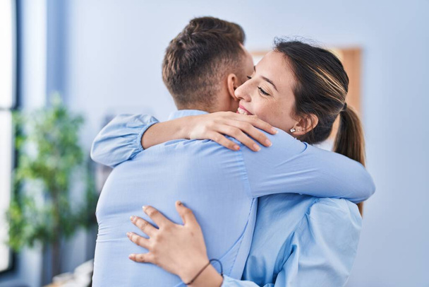 Homem e mulher empresários abraçando uns aos outros no escritório - Foto, Imagem