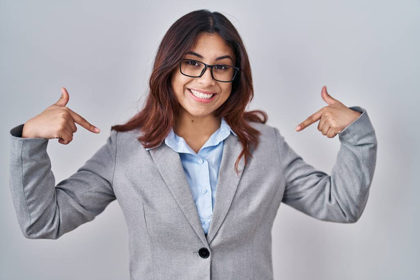Hispanic young business woman wearing glasses looking confident with smile on face, pointing oneself with fingers proud and happy.  - Photo, Image