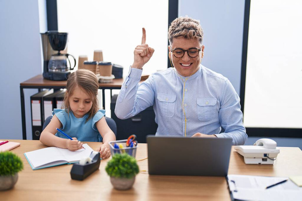 Молодий батько і дочка працюють в офісі разом посміхаючись з ідеєю або питанням, вказуючи пальцем щасливе обличчя, номер один
  - Фото, зображення