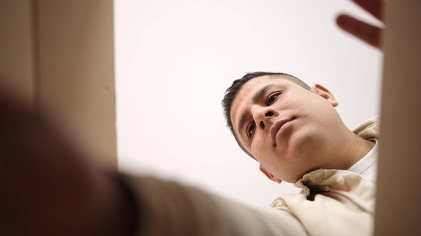 Joven hombre hispano desempacando caja de cartón en casa - Foto, Imagen
