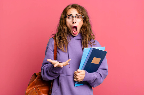 hispanic pretty woman feeling extremely shocked and surprised. university student concept - 写真・画像
