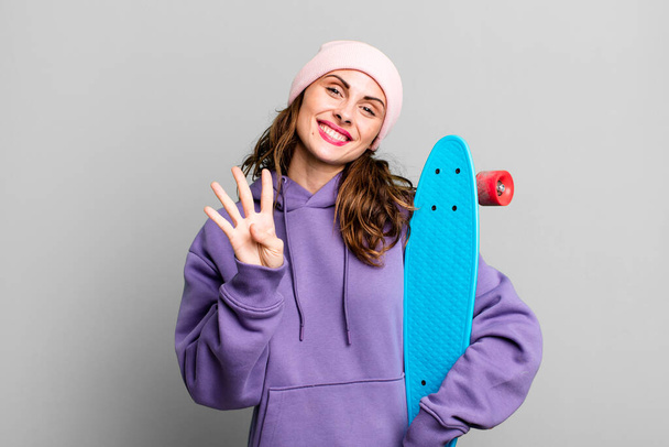 hispanic pretty woman smiling and looking friendly, showing number four. skate boarding concept - Foto, imagen