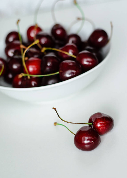 Juicy cherries on a white plate, close-up - Φωτογραφία, εικόνα