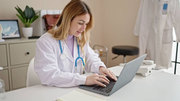 Nuori kaunis latino nainen lääkäri käyttää kannettavaa tietokonetta työskentelee klinikalla - Valokuva, kuva