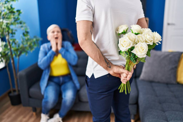 Matka i syn niespodzianka z kwiatami w domu - Zdjęcie, obraz