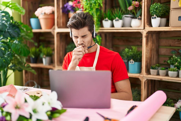 Young hispanic man working at florist shop doing video call feeling unwell and coughing as symptom for cold or bronchitis. health care concept.  - Photo, image