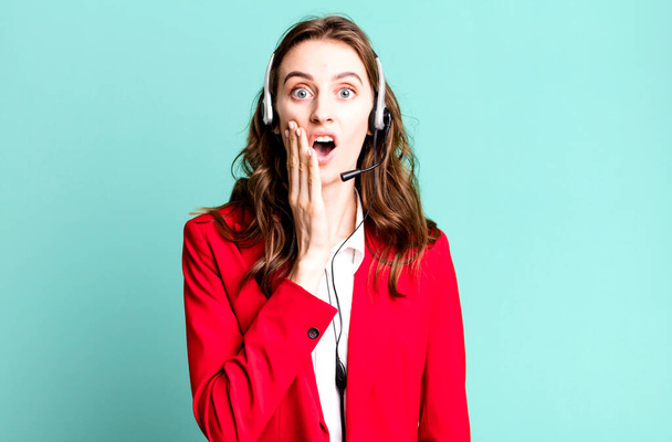 young pretty woman feeling shocked and scared. telemarketer concept - Foto, Imagen