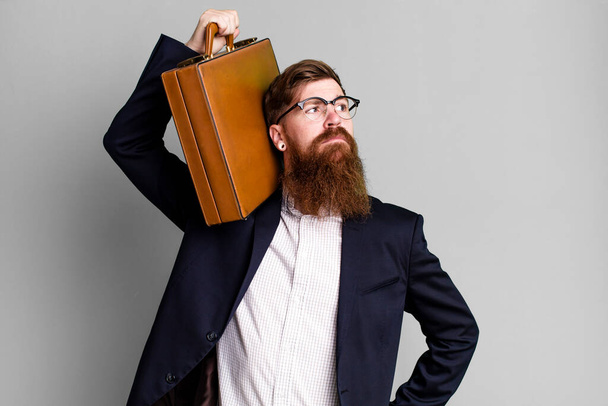 young adult red hair bearded cool businessman with a leather suitcase - Photo, Image