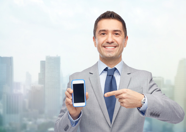 happy businessman showing smartphone screen - Foto, afbeelding