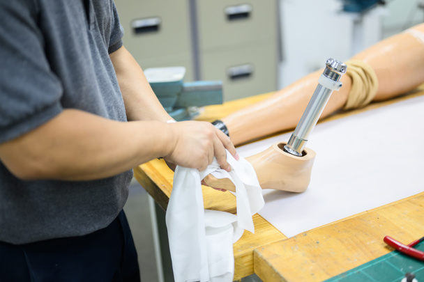 Miespuolinen työntekijä kokoamassa keinotekoisen jalan osia proteesituotantotyöpajassa, Kehitysinsinööri, jolla on huipputeknologiaa proteesien valmistuksessa, Uusi keinotekoinen raajojen tuotanto - Valokuva, kuva