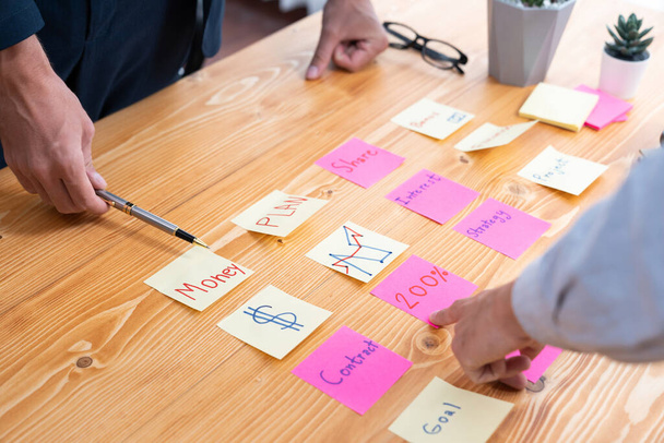 Üzleti csapat összegyűlnek az asztalon, ötletelés és írás kreatív ötlet színes post-it jegyzetek. Tervezés és ötletbörze stratégia az üzleti célok eléréséhez. buzgó - Fotó, kép