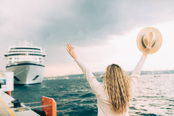 Mulher turista em pé na frente de grande navio de cruzeiro, viajar feminino.  - Foto, Imagem