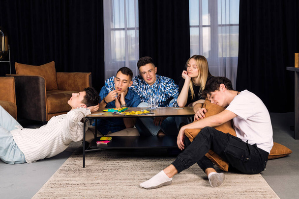 Five friends spending time together, get bored. Small group of friend in a living room, boring party or friends meeting. - Fotoğraf, Görsel