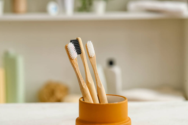 Porte-brosses à dents en bambou sur table blanche dans la chambre - Photo, image